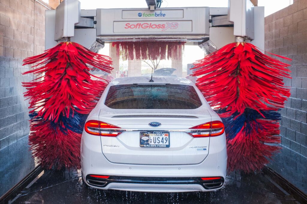 White car getting brushed in an automatic car wash