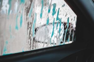 Soap and foam on the side window of a car looking from the interior
